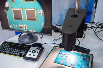 Chips on a microboard. Computer chips under an electron microscope. Enlarged processors in monitor screen. Printed circuit boards. Checking processor on microboard. Chip testing concept.