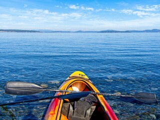 Red and yellow kayak ready to launch at the ocean shore