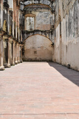 Fototapeta na wymiar Ruinas de Santa Clara en Antigua Guatemala. Corredor rodeado de arcos antiguos de piedra.