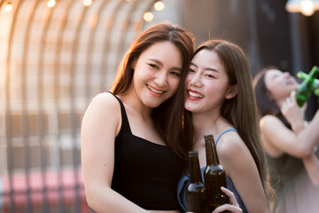 Group of women celebrating outdoors in hand holding beer bottles. merry bright smiley face sunset atmosphere.