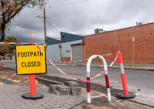 'Footpath closed' warning sign in front of a sidewalk construction site