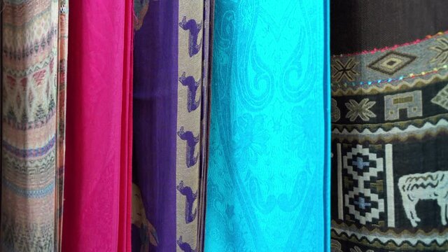 Colorful pashmina shawls closeup in showroom. Retail store, buy, sell concept