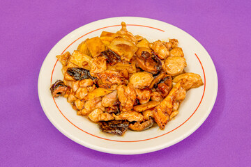Recipe cooked by an Asian chef of stewed beef with bamboo and Chinese mushrooms with soy sauce on purple table