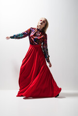 Fashion photo of young woman in red dress. Studio
