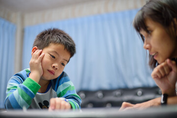 children boy doing homework with mother, kid write paper, family concept, learning time, student, back to school 
