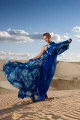 Portrait of a beauty woman in blue dress on the desert