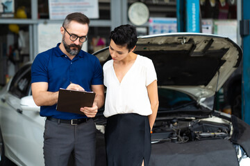 Car insurance concept. Insurance Agent examine Damaged Car with woman customer write information on...