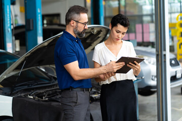Car insurance concept. Insurance Agent examine Damaged Car with woman customer write information on...