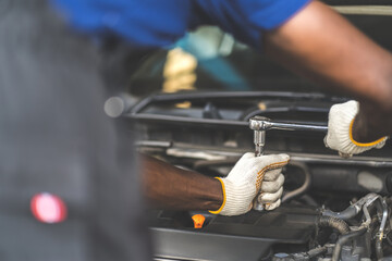 Hands Expertise car mechanic in auto repair service. Car maintenance and auto service garage concept.