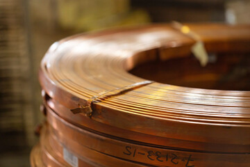 Rolls of flat copper products close-up. Copper tape in bundles. Copper rolling. - obrazy, fototapety, plakaty
