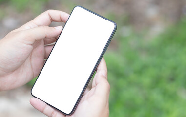 Man's hands holding or using smartphone with two hands. Smartphone with white blank on screen, Cellphone mockup.