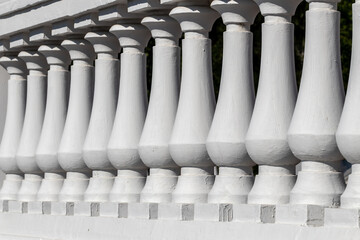 Details of the architecture of the city - a white fence, symmetry of the fence supports of a...