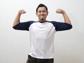 Funny Asian man shows double biceps pose pretending to be a strong person physically and mentally, showing self confidence