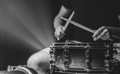 Close-up shot of a drummer playing a snare drum with sticks.