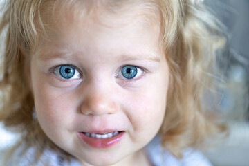 Portrait of a little tear-stained girl with big blue eyes.