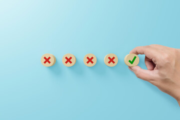 Checklist and check mark concept. Check mark and x sign symbol on wooden blocks on light blue...