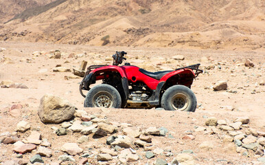 Red ATV on the background of stones in the desert in Egypt