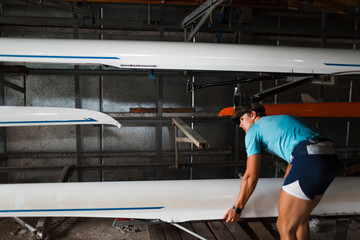 Sportsman single scull man rower prepare to competition with boat. © primipil