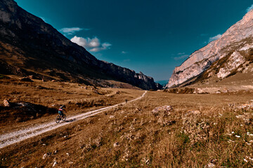 Mans with bicycles riding on country road in the mountains. Mountain biking in the mountains..
