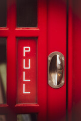 Detail of door old red UK Telephone  box with PULL text