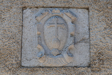 Symbol of the Chartreuse cross on a stone

