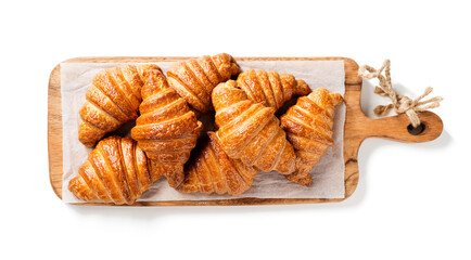 French croissants for breakfast. Freshly baked croissants on wooden cutting board, isolated on  white background . top view