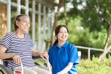 車椅子に乗る高齢者と女性介護士
