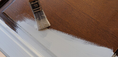 a brown kitchen cabinet is painted with white chalk paint 
