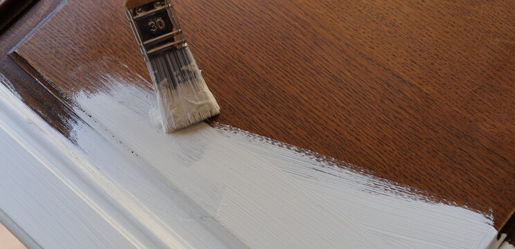 A Brown Kitchen Cabinet Is Painted With White Chalk Paint 