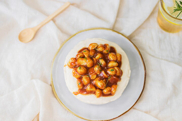 Caramel macadamia cheese pie on plate with warm sunlight in garden; top view.