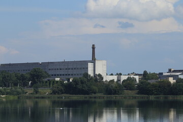 Fototapeta na wymiar Factory with a chimney by the lake