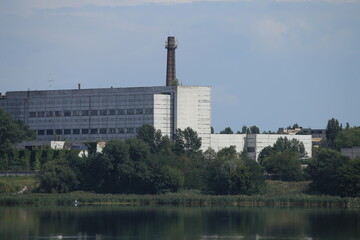 Factory with a chimney by the lake