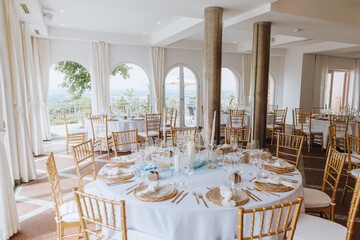 Schön gedeckter und geschmückter Raum für eine Hochzeit in weiß und gold mit türkis