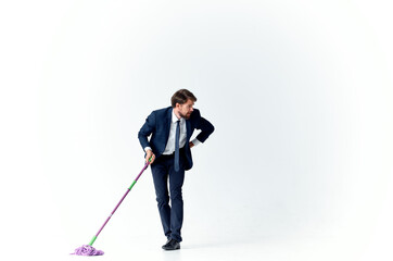 business man in a suit with a mop in his hands cleaning service