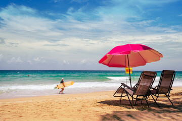beach chairs and umbrella on the beach.Surfboard on tropical beach in summer beach sunny day.