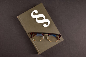 sign paragraph glasses and books on black stone background