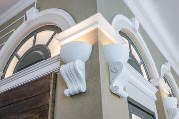 Detail of corner ceiling with intricate crown molding on column with spot light.