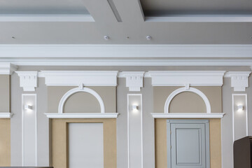 Detail of corner ceiling with intricate crown molding on column with spot light.