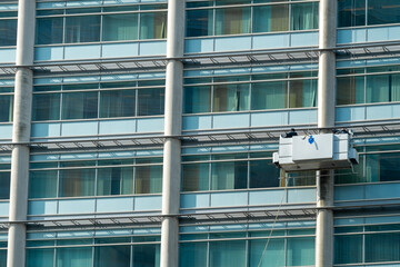Window cleaners at work at a great height in a gondola at the uwv building in Amsterdam Sloterdijk, Noord-Holland Province, The Netherlands - obrazy, fototapety, plakaty