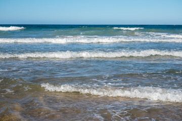 Fototapeta na wymiar waves on the barrosa beach, at low tide, in sancti petri, cadiz