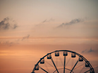 Silhouette of a Ferris wheel at sunset