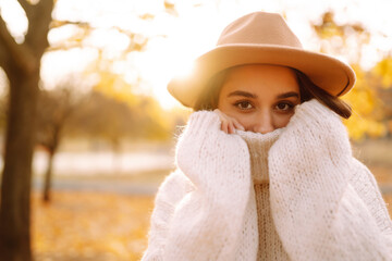 Stylish woman enjoying autumn weather in the park. Fashion, style concept.