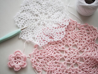 白とピンクのレース編みドイリーと花