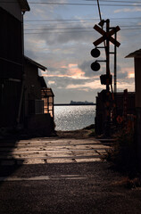 海と踏切が見えるノスタルジックな港町の風景