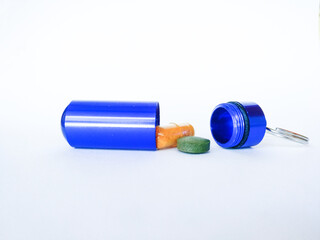 blue pill box with pills on white background