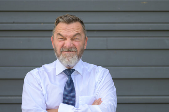 Businessman Pulling A Quirky Face Screwing Up His Eyes