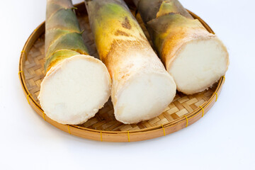 Fresh bamboo shoots in basket on white background.