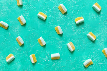 Fruit jelly candies in the form of melon slices on a bright turquoise background. Food background.