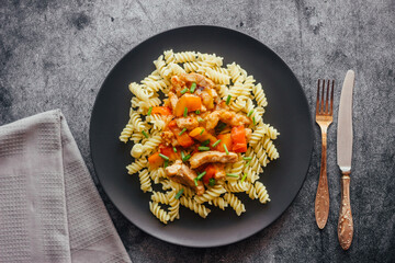 Pork in sweet and sour sauce with pasta. Delicious hot dish on a plate. Pork with bell pepper and green onions