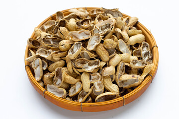 Peanut shells in bamboo basket on white